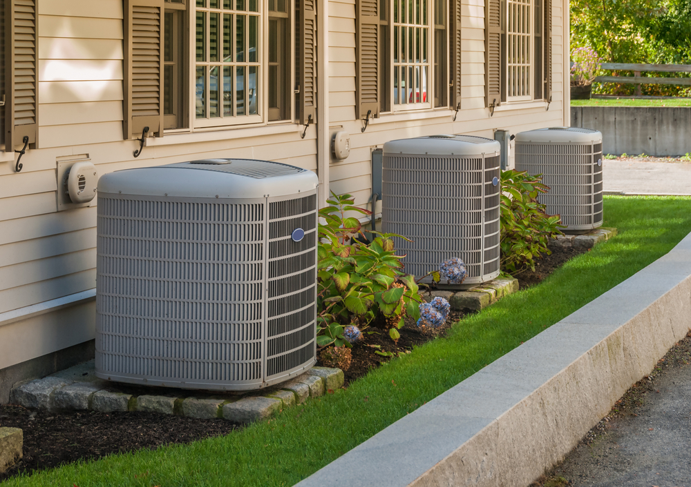 Multiple AC condenser units installed along a home exterior